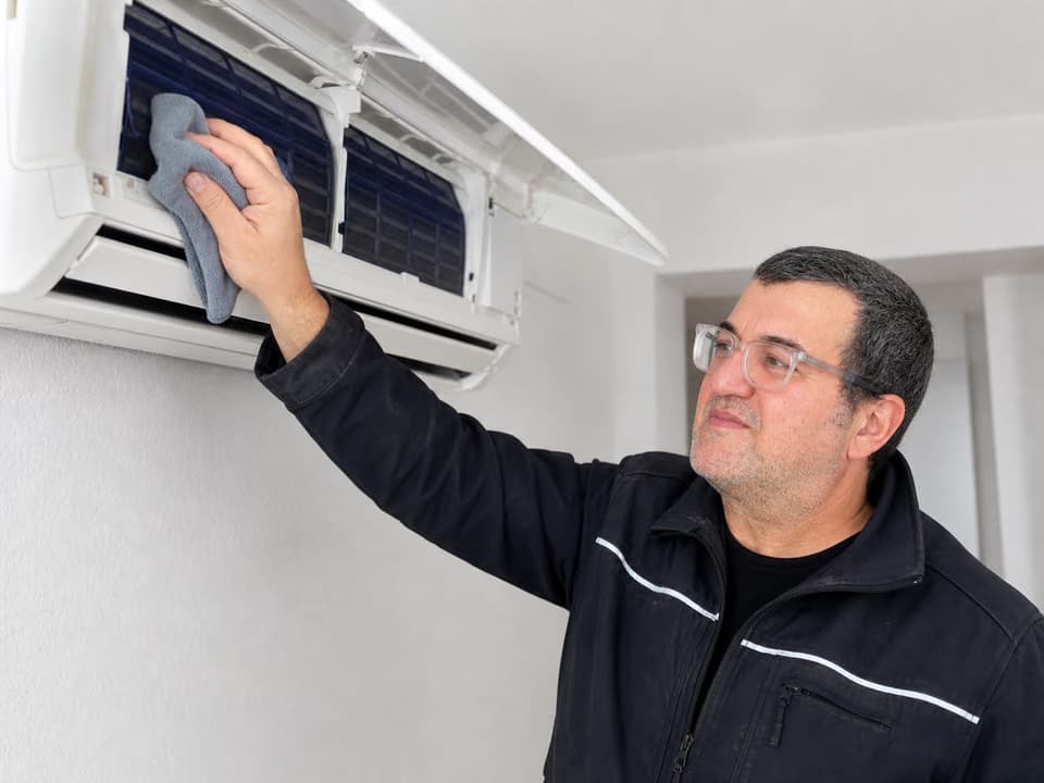 Technicien Climago réalisant l'entretien d'une climatisation en Seine-Saint-Denis